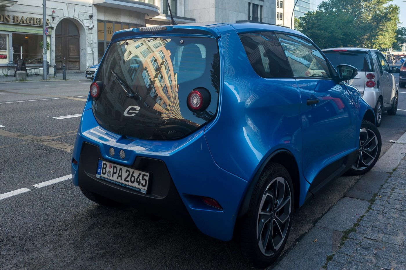 Vehículo eléctrico aparcado en la vía junto a otros turismos